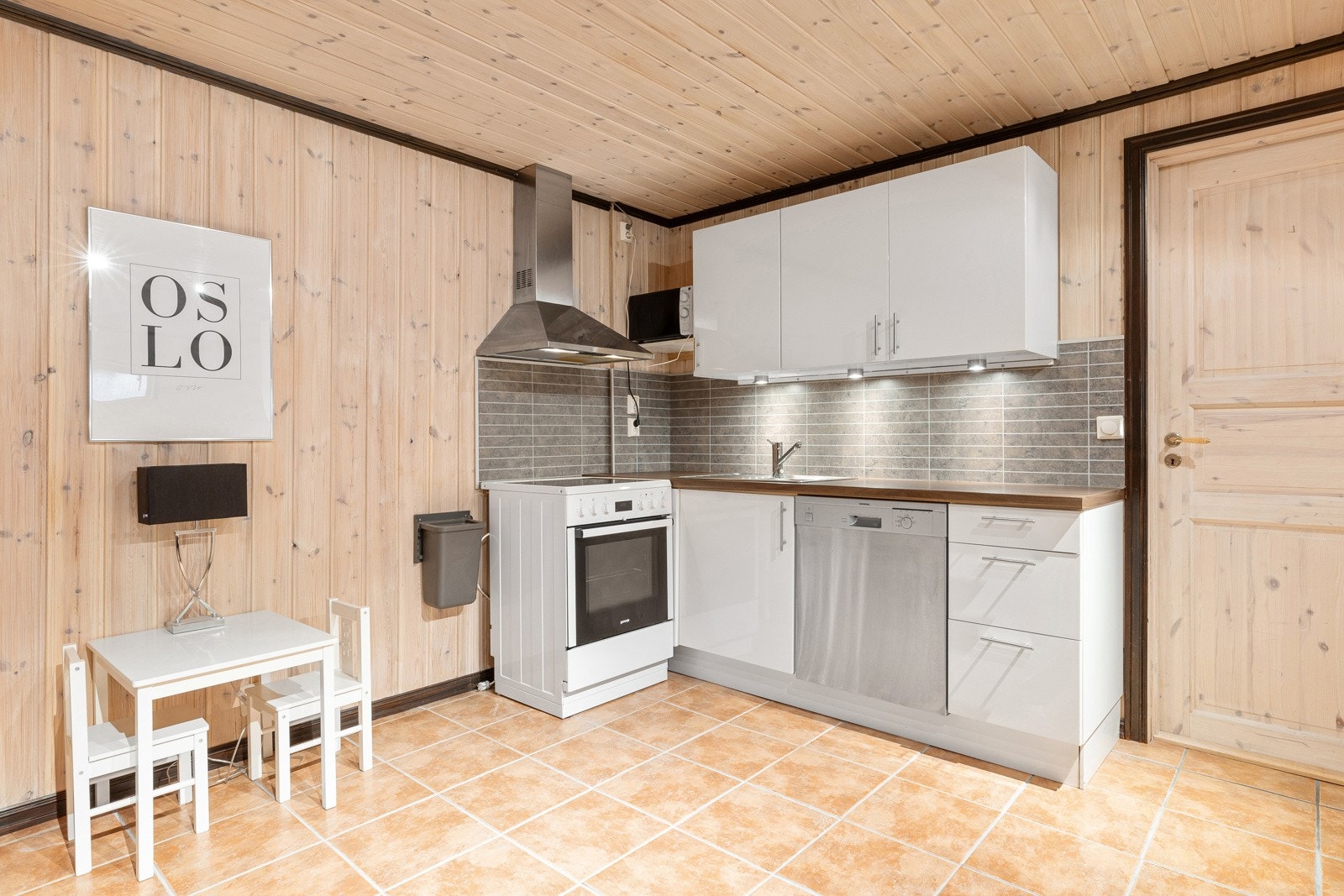 Kjøkken i kjeller - hvit høyglans kjøkkeninnredning med laminat benkeplate. Oppvaskkum og uttak til oppvaskmaskin Galleribilde