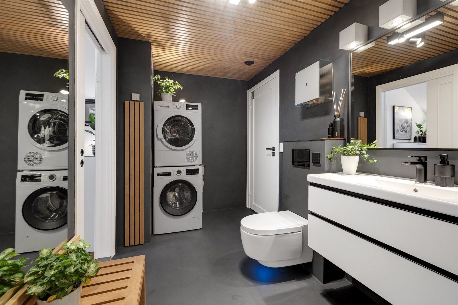 Badet er innredet med veggmontert innredning fra 2021, dusjnisje med glassvegg fra Novellini, dusjarmatur fra Gustavsberg, Svedberg håndkletørker og Geberit AquaClean Mera Comfort spyletoalett med innebygget sisterne. Galleribilde