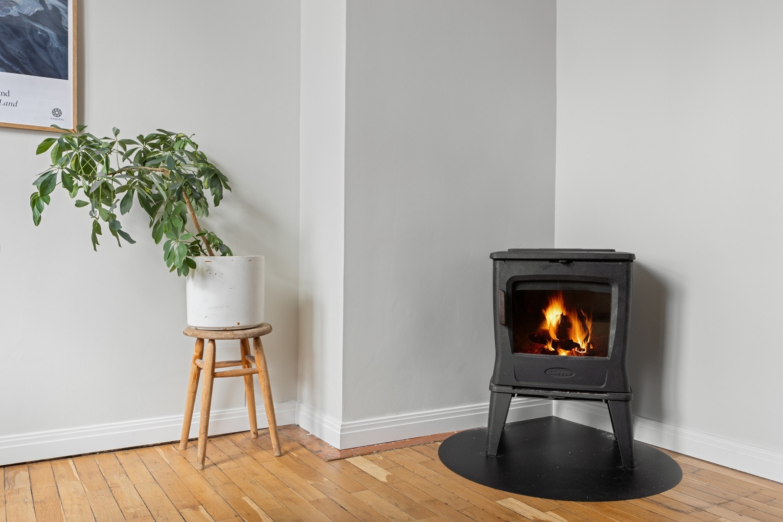 Kjøkkenet har lyse, glatte veggflater, orginale gulv i heltre eik, profilert listverk og hygge fra en peisovn. Galleribilde
