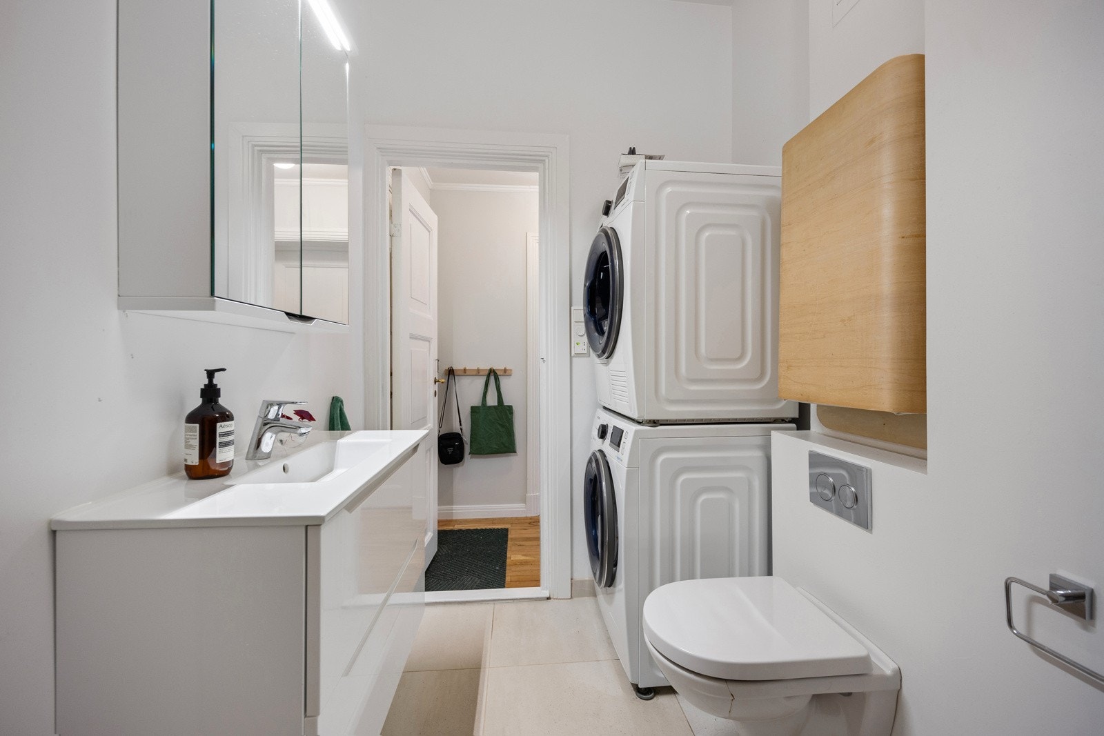 Badet er moderne, med pen innredning, veggmontert toalett, gulvvarme og opplegg for vaskesøyle. Galleribilde