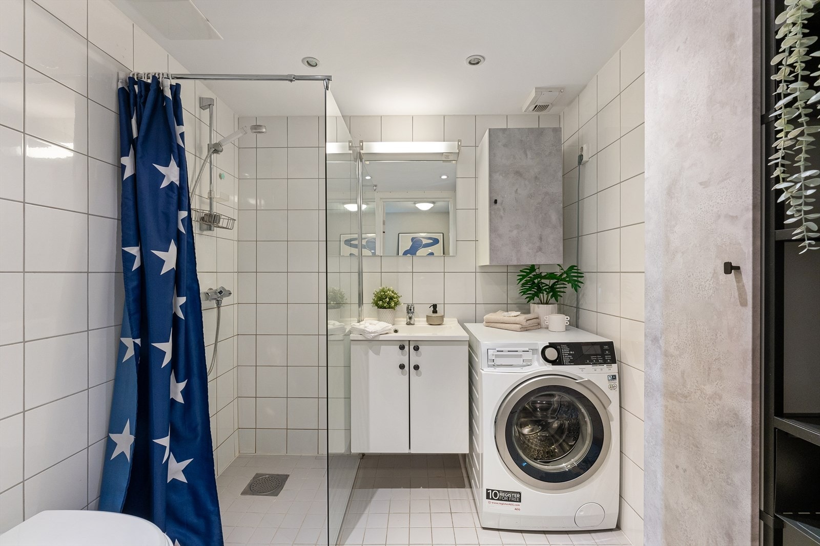 Pent bad med flislagt gulv med varmekabler, flislagte vegger og malt himling med downlights Galleribilde