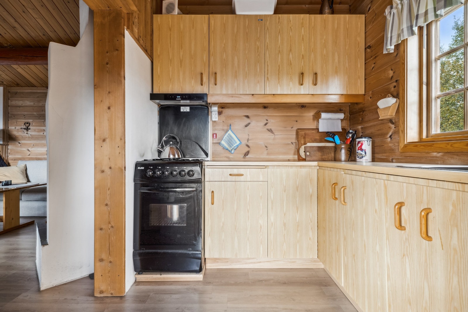 Kjøkkenet har kjøkkeninnredning i hjørneløsning med glatte fronter og laminerte benkeplater. Innredningen består av overskap på en vegg og underskap og en skuff. Galleribilde