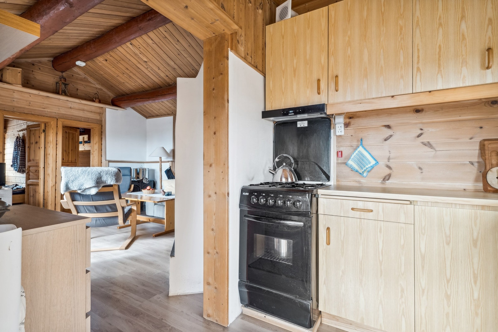 Nedfelt vaskekum med ett-greps blandebatteri. Åpen løsning for frittstående gasskomfyr i enden av innredningen. Kjøkkenventilator med kullfilter montert over komfyrplassen. Galleribilde