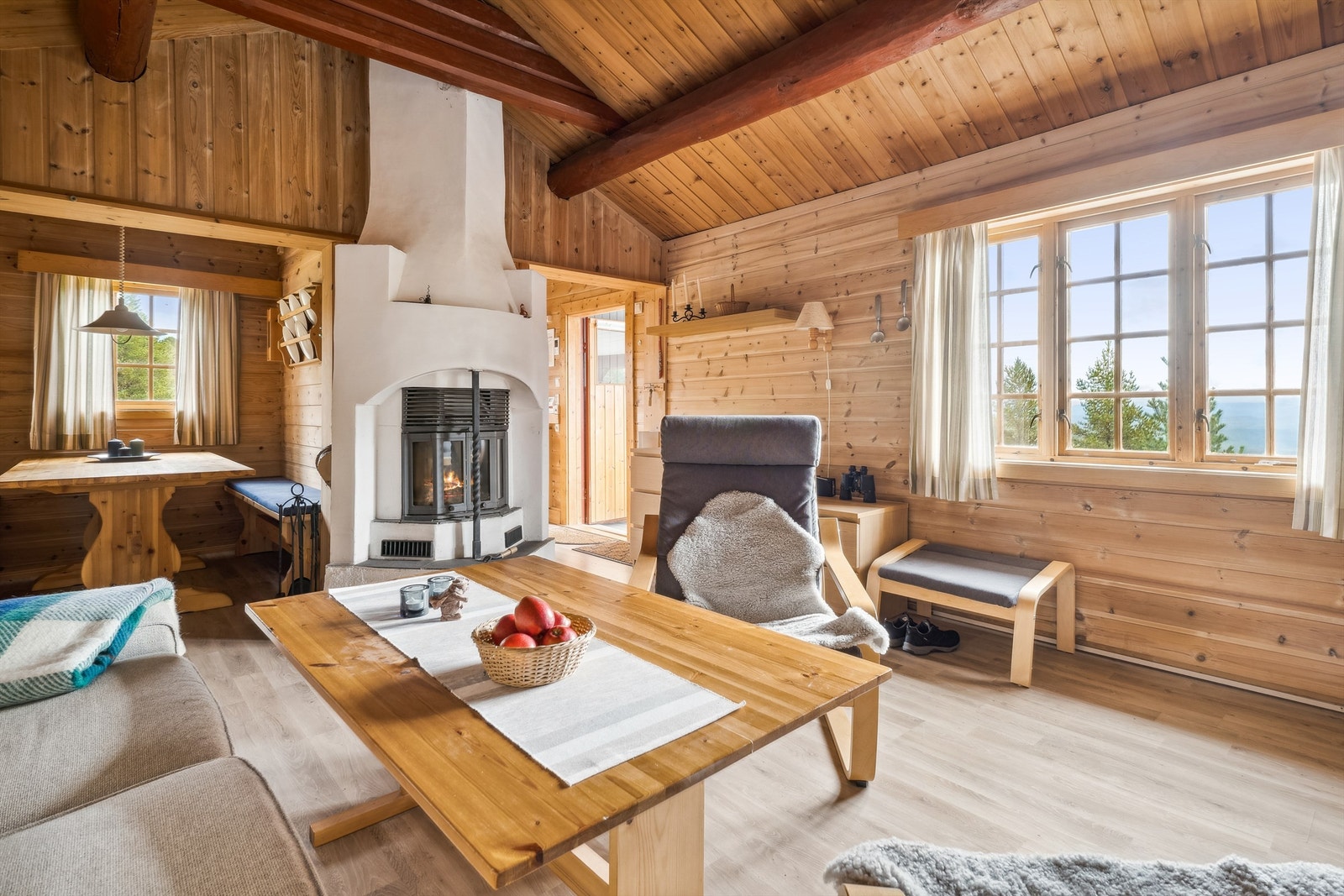 Denne peisen er varmekilden i hytta. Ett stort vindu slipper høstsolen godt inn i rommet, og lyser opp. Galleribilde