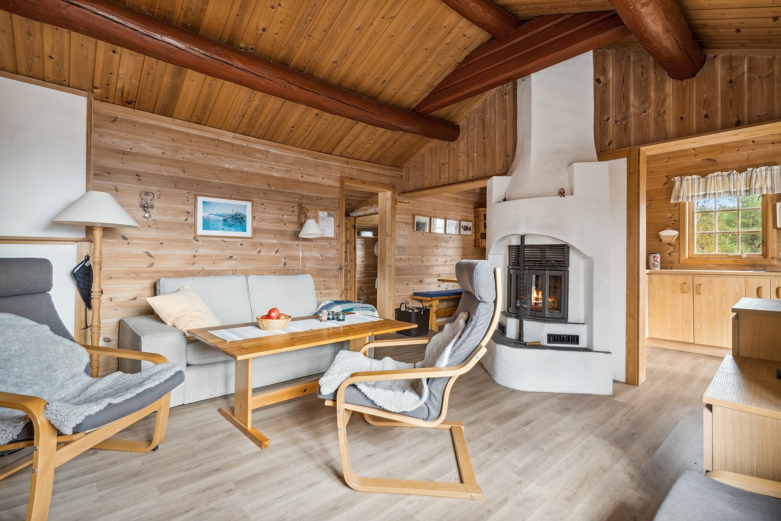 Rommet er romslig med elementpeis montert midt i stuen mellom kjøkkenet og spisestuen. Galleribilde