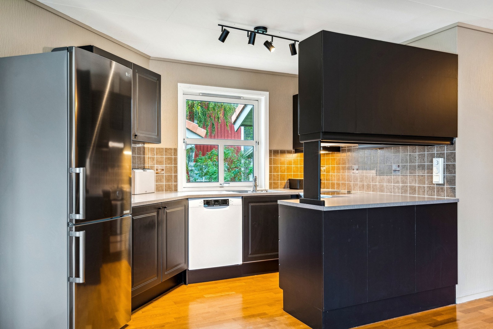 Kjøkken - kjøkkenøya med overskap sørger for et naturlig skille mellom sonene Galleribilde