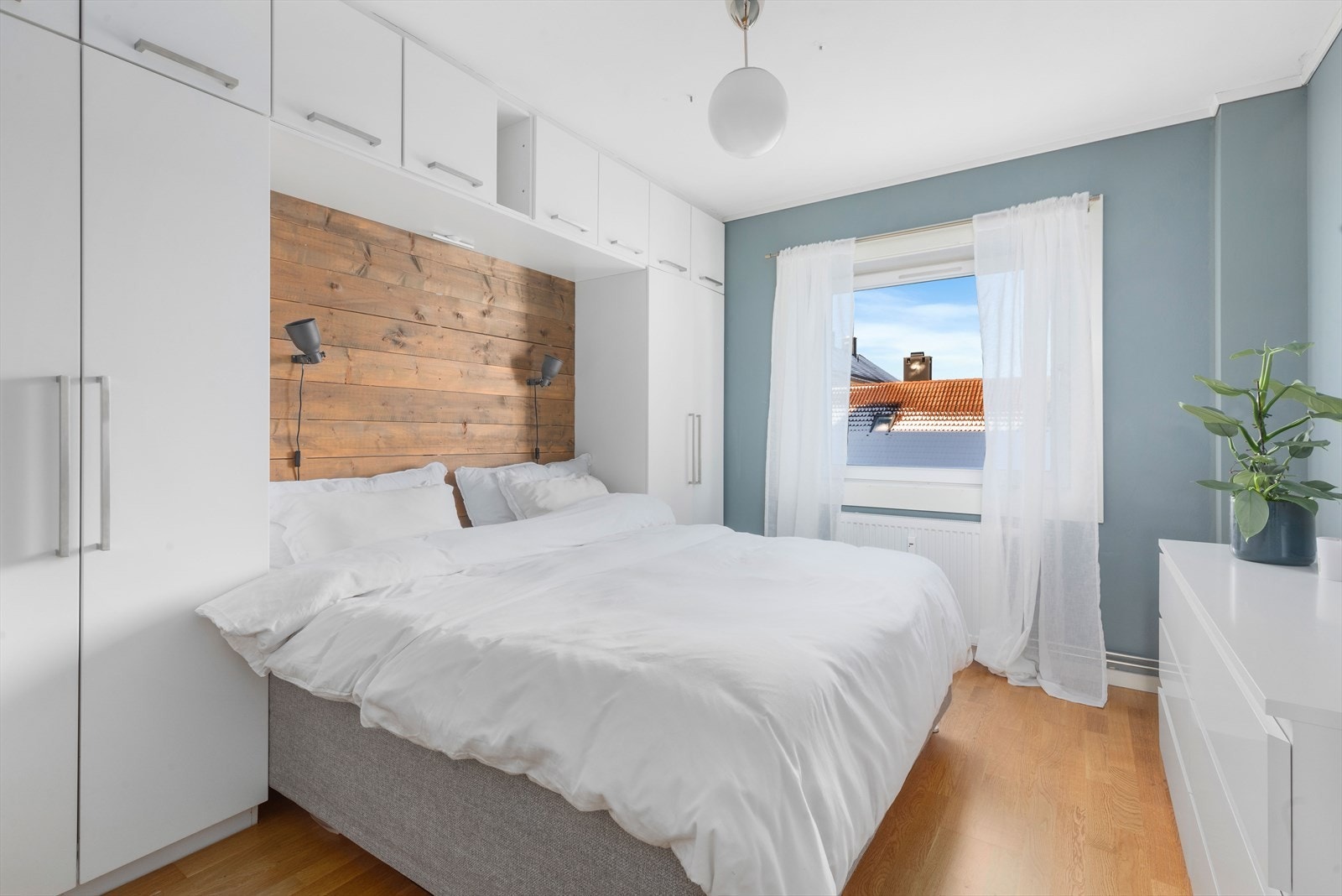 Romslig hovedsoverom med plassbygget skap rundt seng. Galleribilde