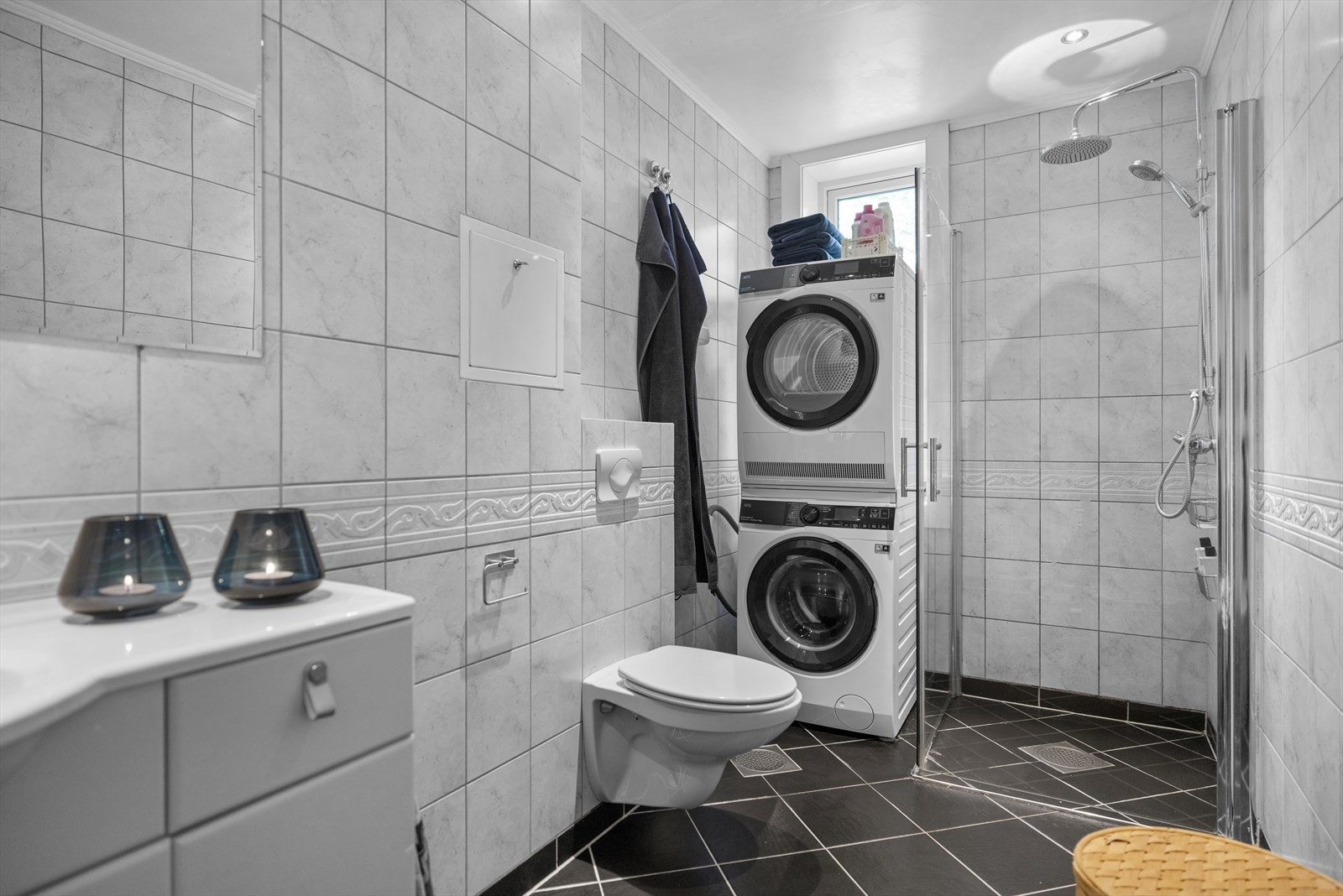 Stort flislagt bad med dusjhjørne. Badet har behov for oppussing. Galleribilde