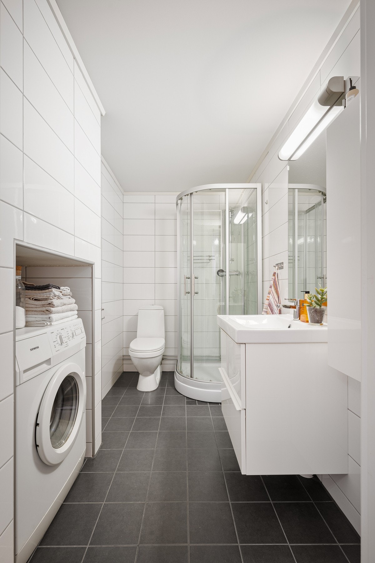 Flislagt bad oppgradert i 2015 som inneholder dusjkabinett, servant, toalett og opplegg og plass for vaskemaskin Galleribilde