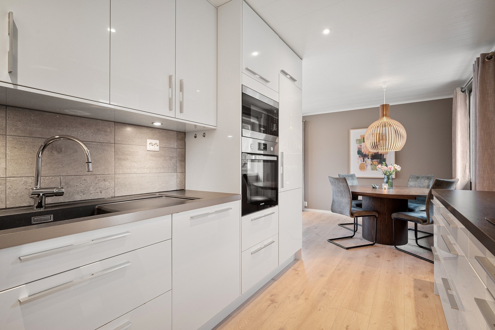 Gjennomført og stilrent med fliser mellom benkeplate og skap Galleribilde