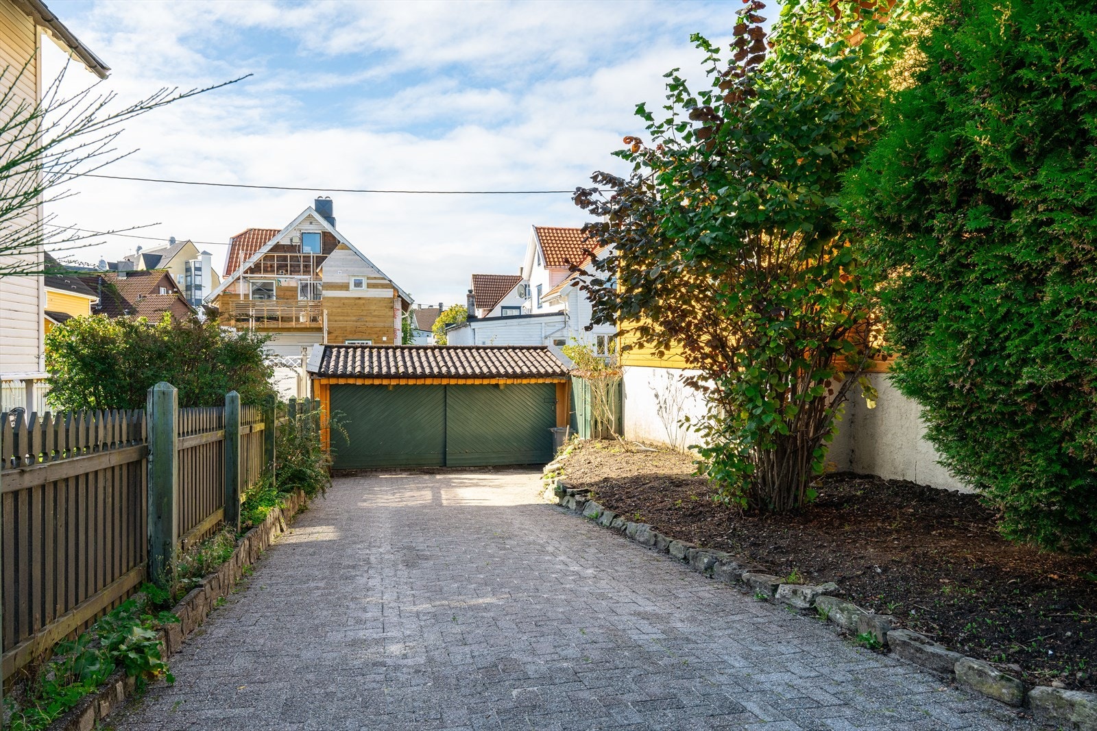 Eiendommen har romslig gårdsrom med plass til flere biler og stor garasje. Galleribilde