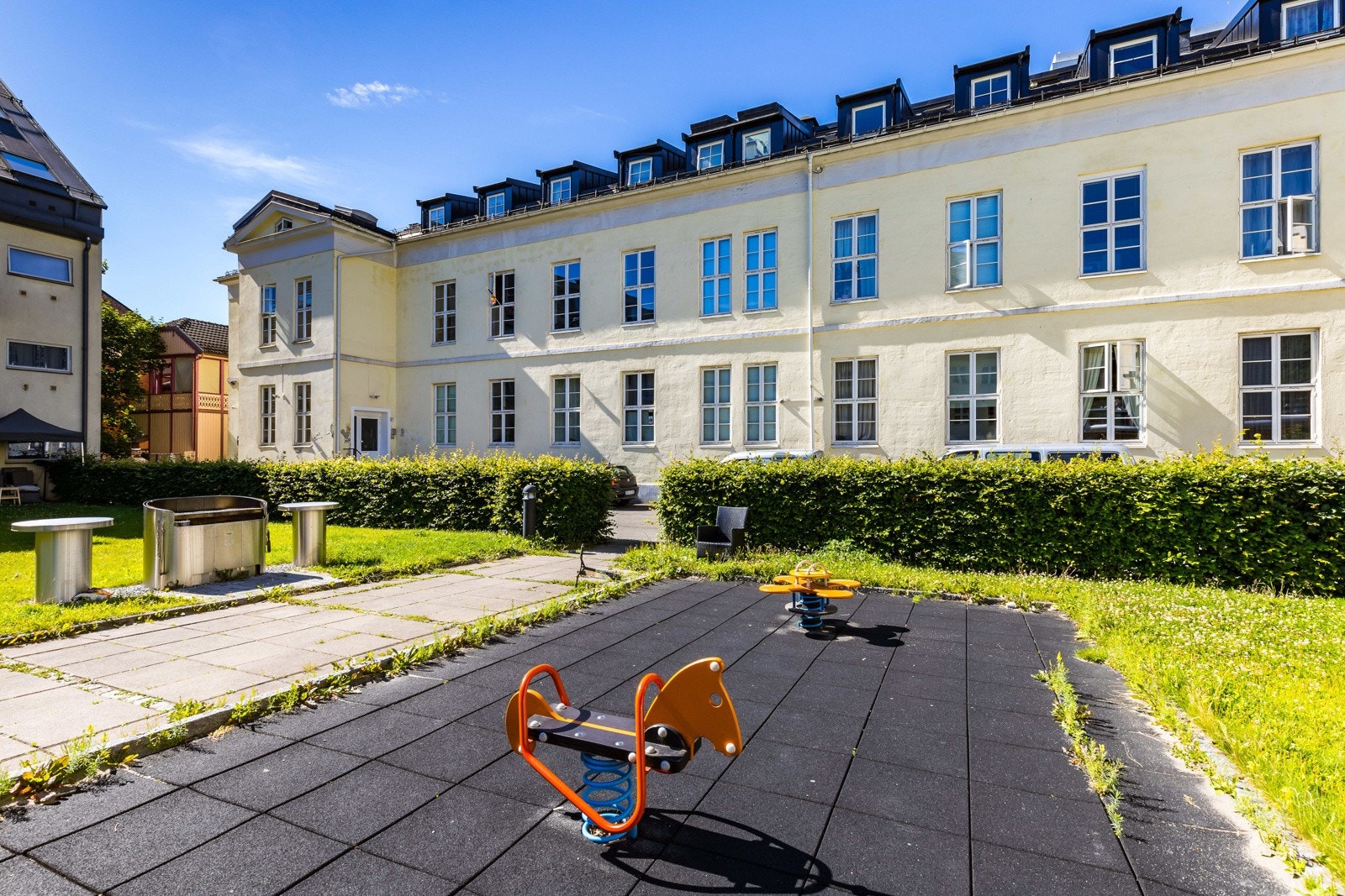 Uteplassen byr på en liten lekeplass med et par apparater, og for øvrig innbyr plenen til ballspill og annen moro. Galleribilde