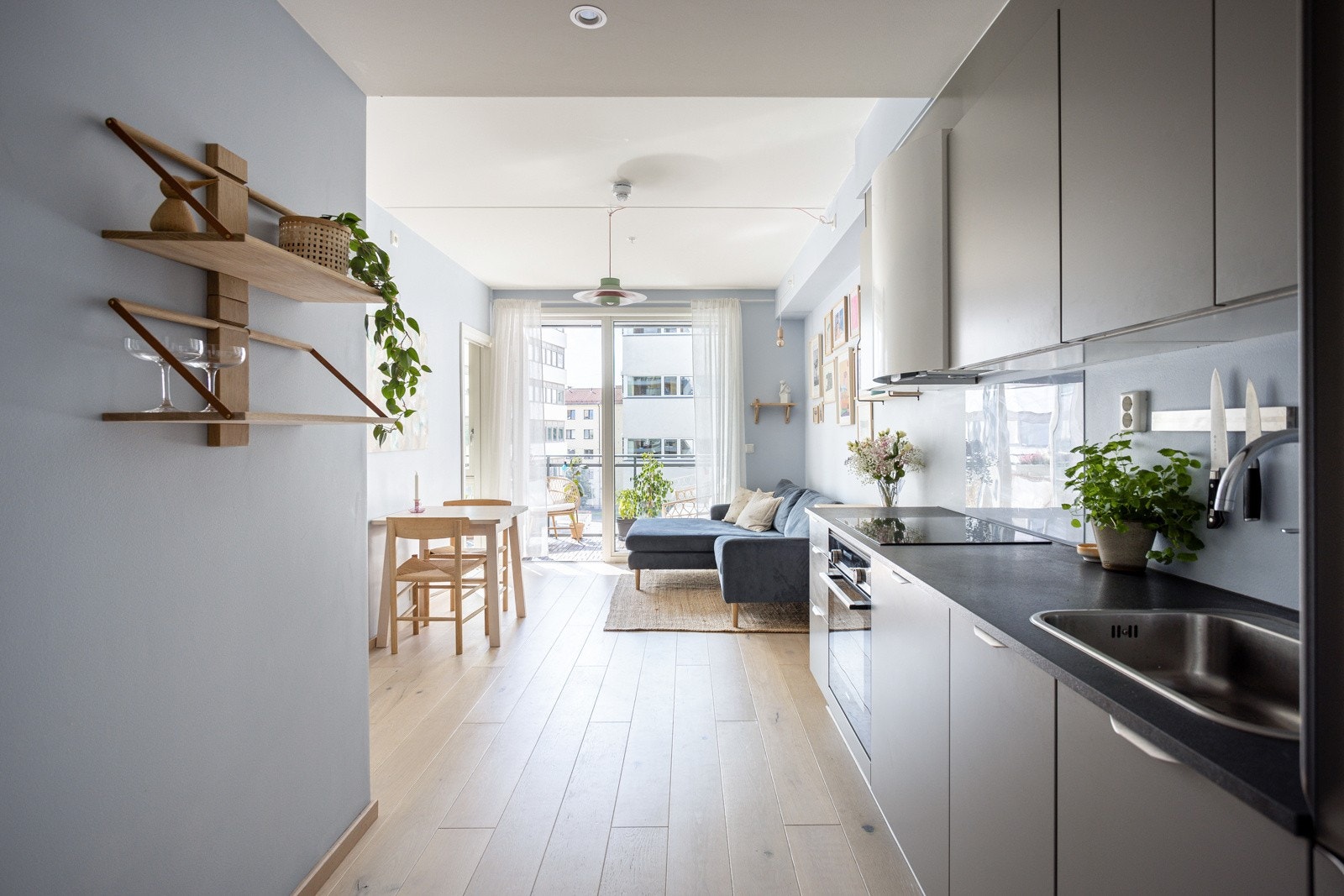 Innredningen har glatte fronter i en fin farge og laminert benkeplate med nedfelt oppvaskkum. Praktisk med glassplate i benkeryggen ved platetoppen og belysing under overskapene. Galleribilde