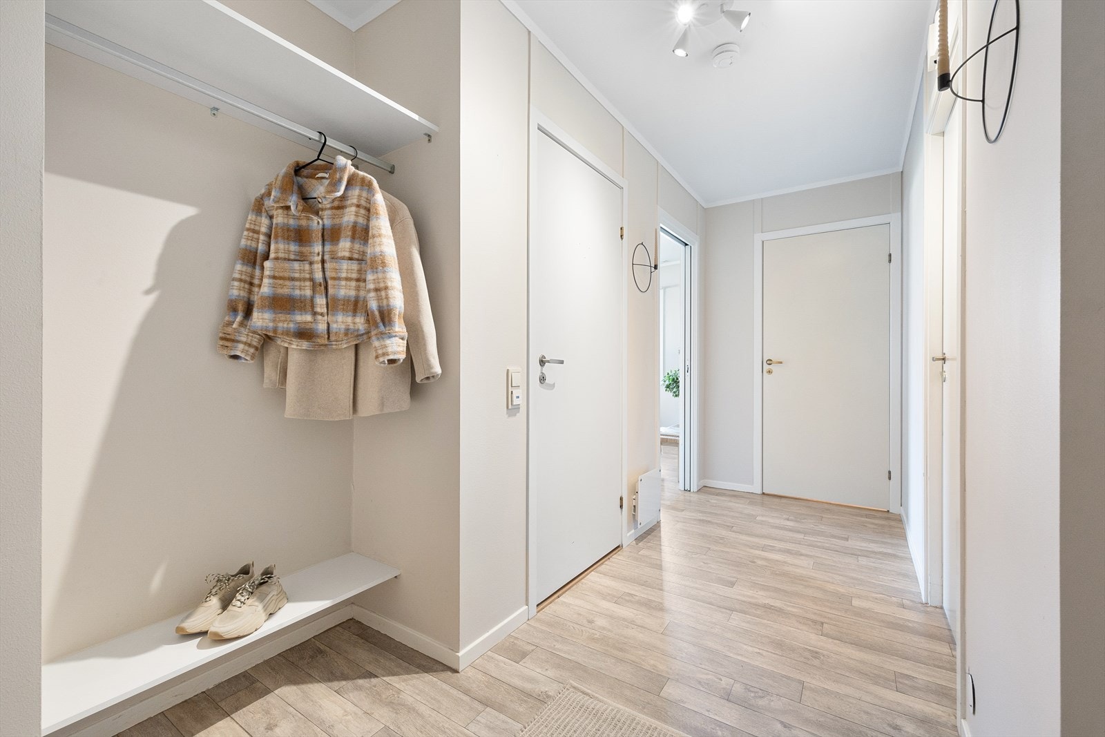 En lun og lys entré/gang med plass til å henge fra seg yttertøy og sko Galleribilde
