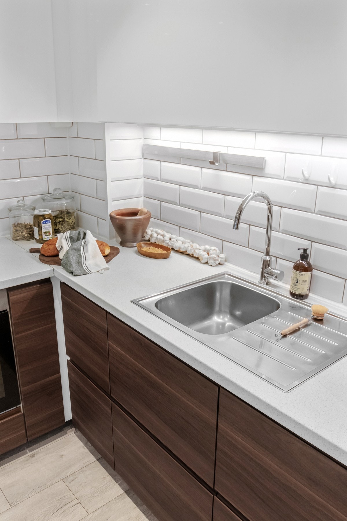 Benkeplaten i laminat kombinerer holdbarhet med et stilrent utseende. Det er lagt tidløse fliser mellom benkeplaten og overskapene. Galleribilde