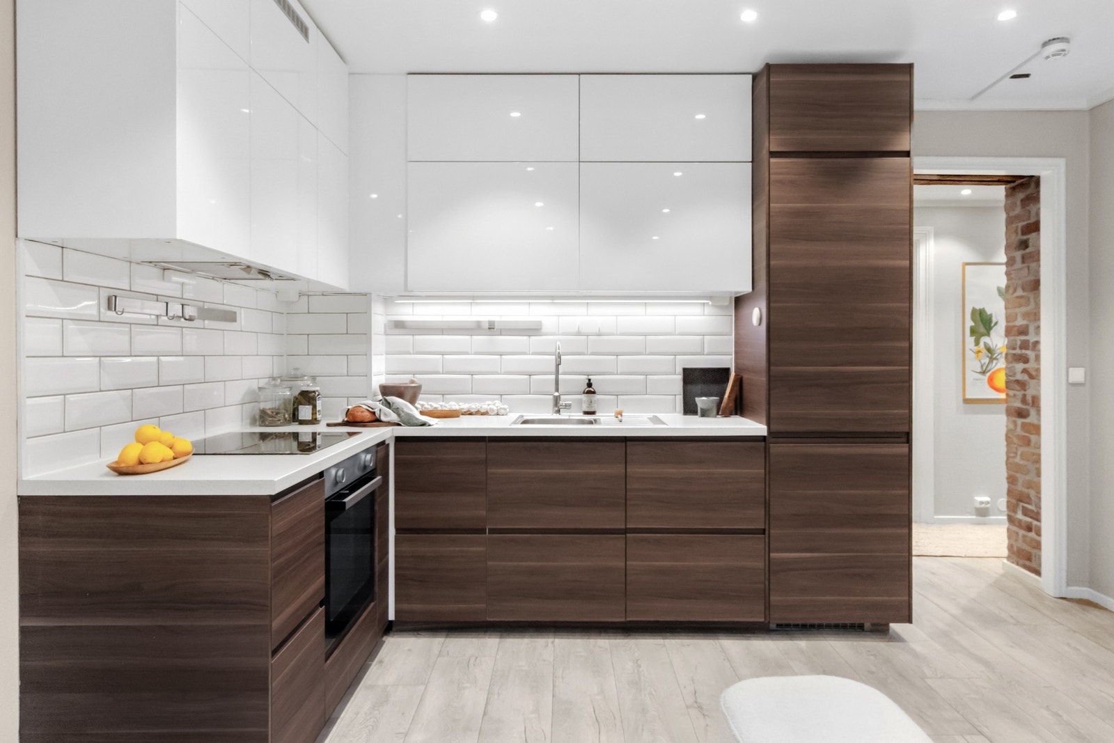 Innredningen har glatte fronter i en dyp brun tone som står i kontrast til de hvite overskapene i høyglans. Galleribilde