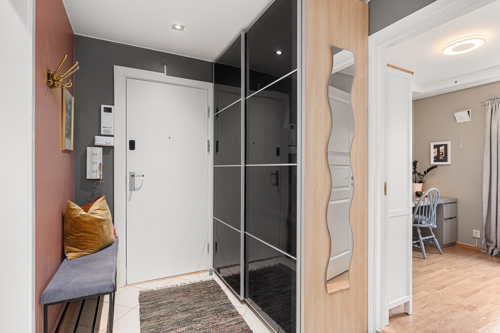 Når du trer inn i leiligheten, blir du møtt av en lys og innbydende entré. Her er det god plass til å henge av seg yttertøy og sette fra seg skoene i en romslig skyvedørsgarderobe. Galleribilde