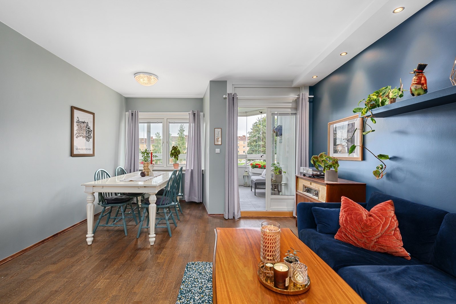 Den romslige stuen er malt i duse jordfarger og har store vindusflater som slipper inn rikelig med naturlig lys. Her er det god plass til både sofagruppe og spisebord. Galleribilde