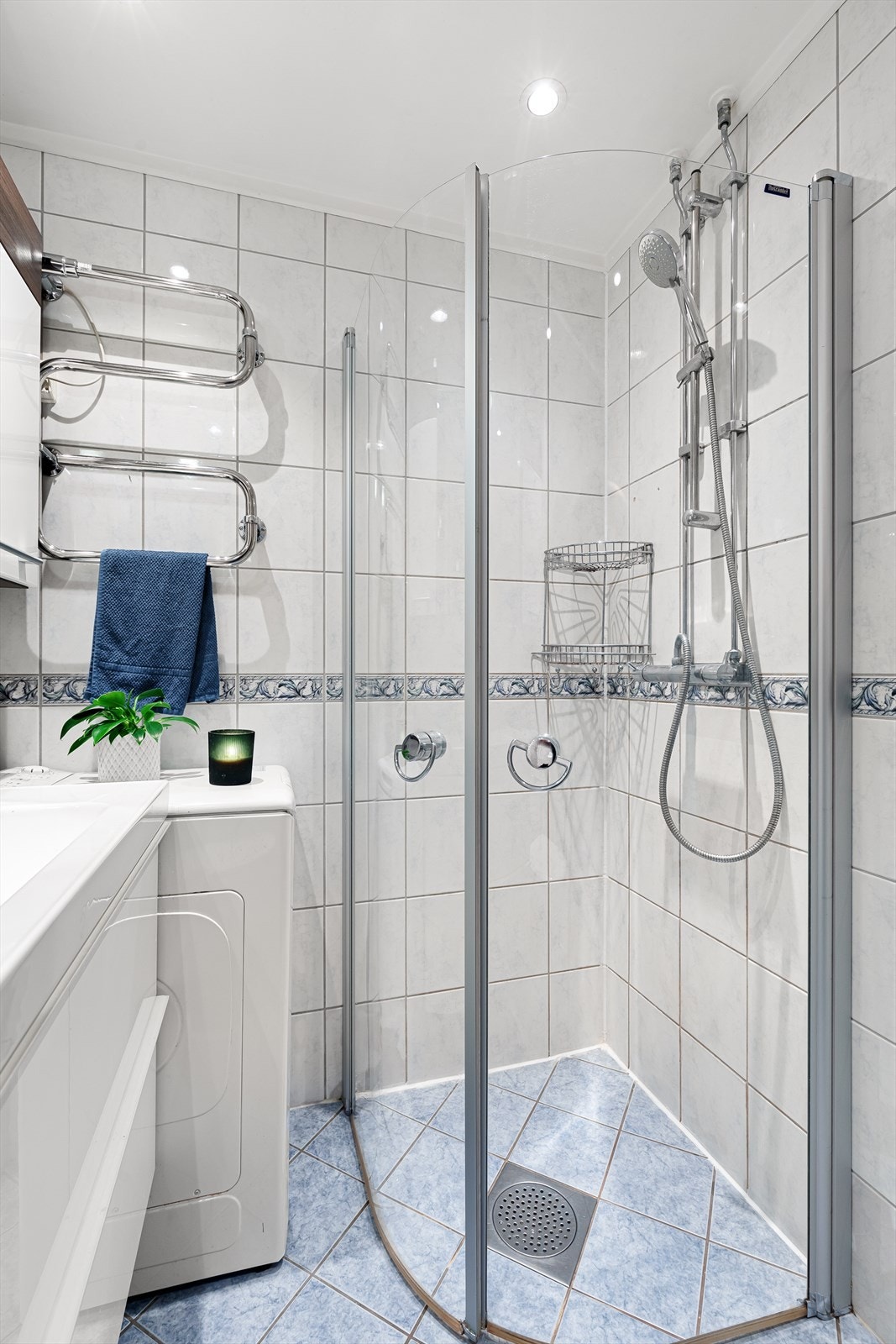 Badet er utstyrt med dusj med innfellbare glassvegger, en stilren innredning med heldekkende servant, speilskap med integrert belysning og et moderne toalett. Her er det også opplegg for vaskemaskin. Galleribilde