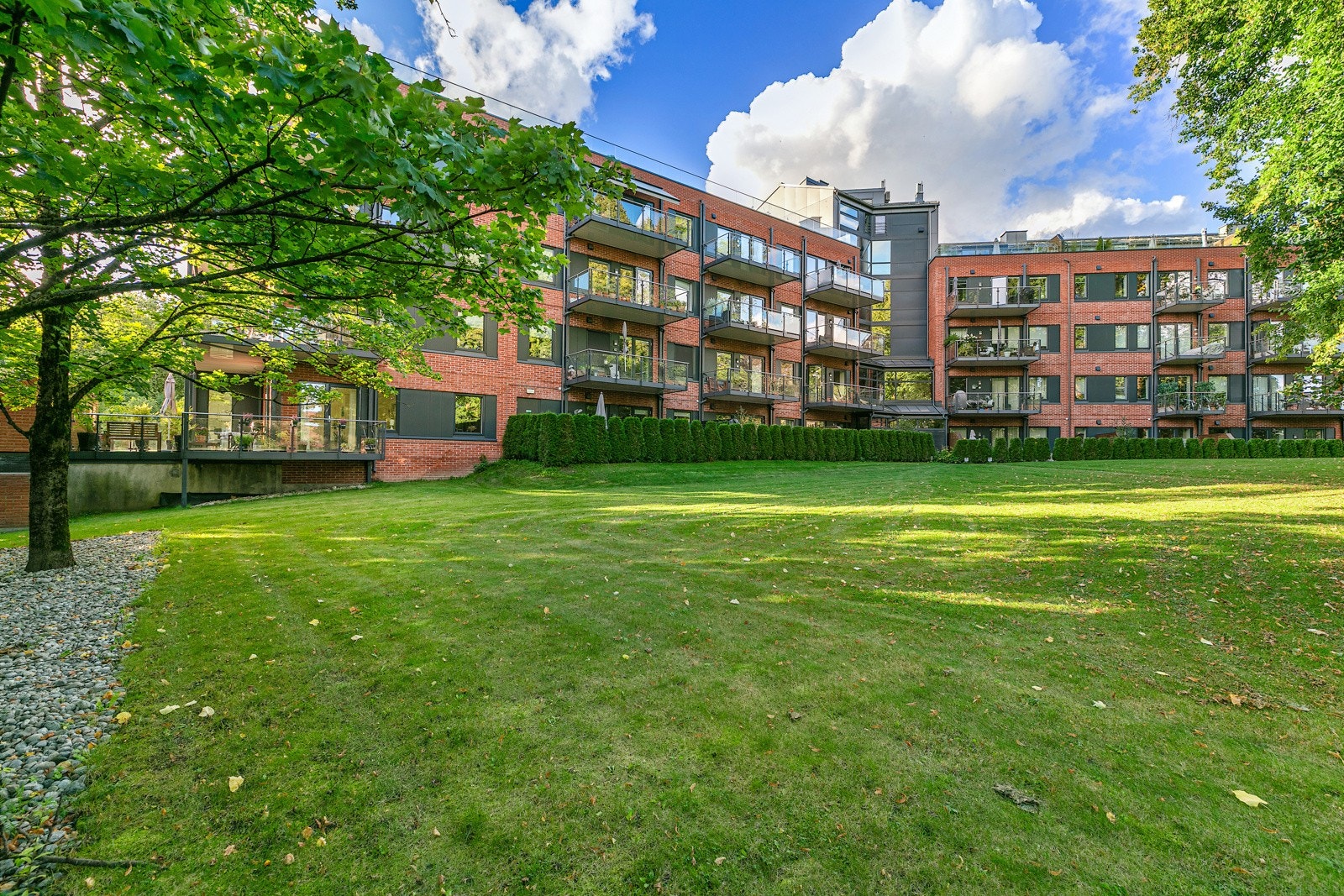 Sameiet disponerer pent opparbeidede grøntarealer med sittegrupper og pen beplantning Galleribilde