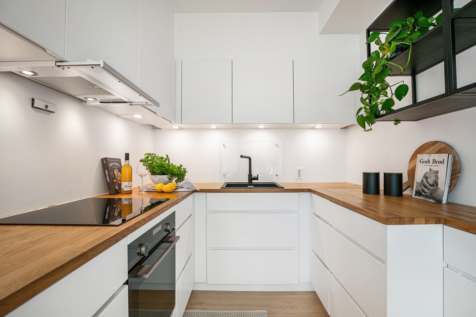 Innredningen har integrerte hvitevarer som kjøleskap med fryser, koketopp, stekeovn og oppvaskmaskin Galleribilde