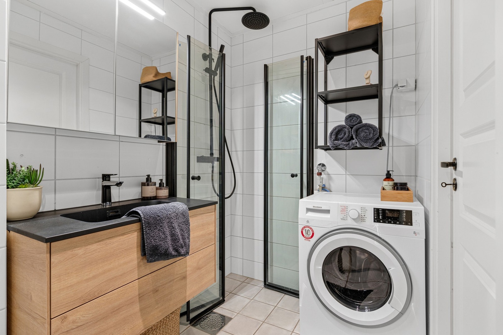 Lyst baderom med opplegg for vaskemaskin. Galleribilde