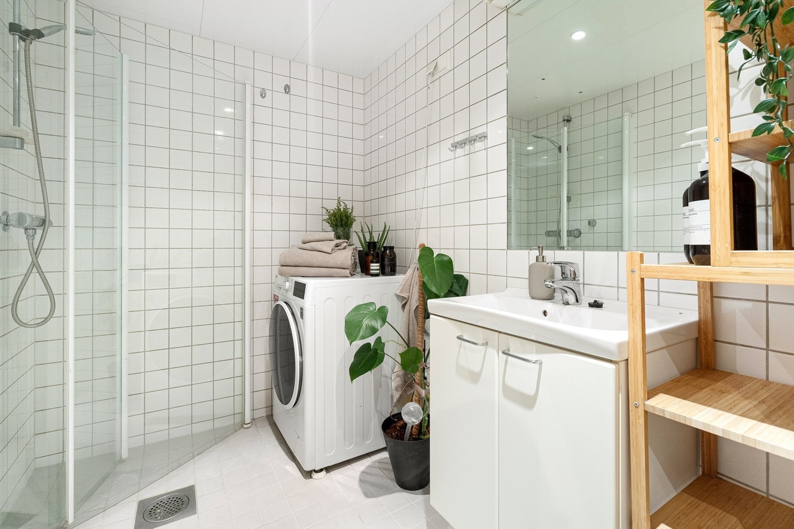 Badet er utstyrt med mekanisk avtrekk, rørfordelingsskap, stoppekran, opplegg for vaskemaskin, innfellbare dusjdører og veggmontert wc Galleribilde