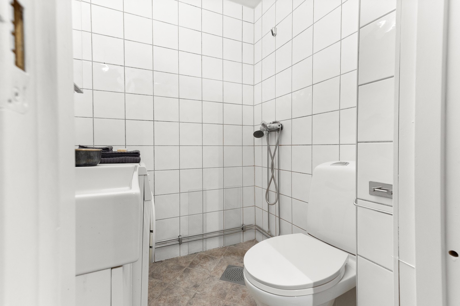 Lys bad med dusj, toalett og baderomsinnredning. Galleribilde