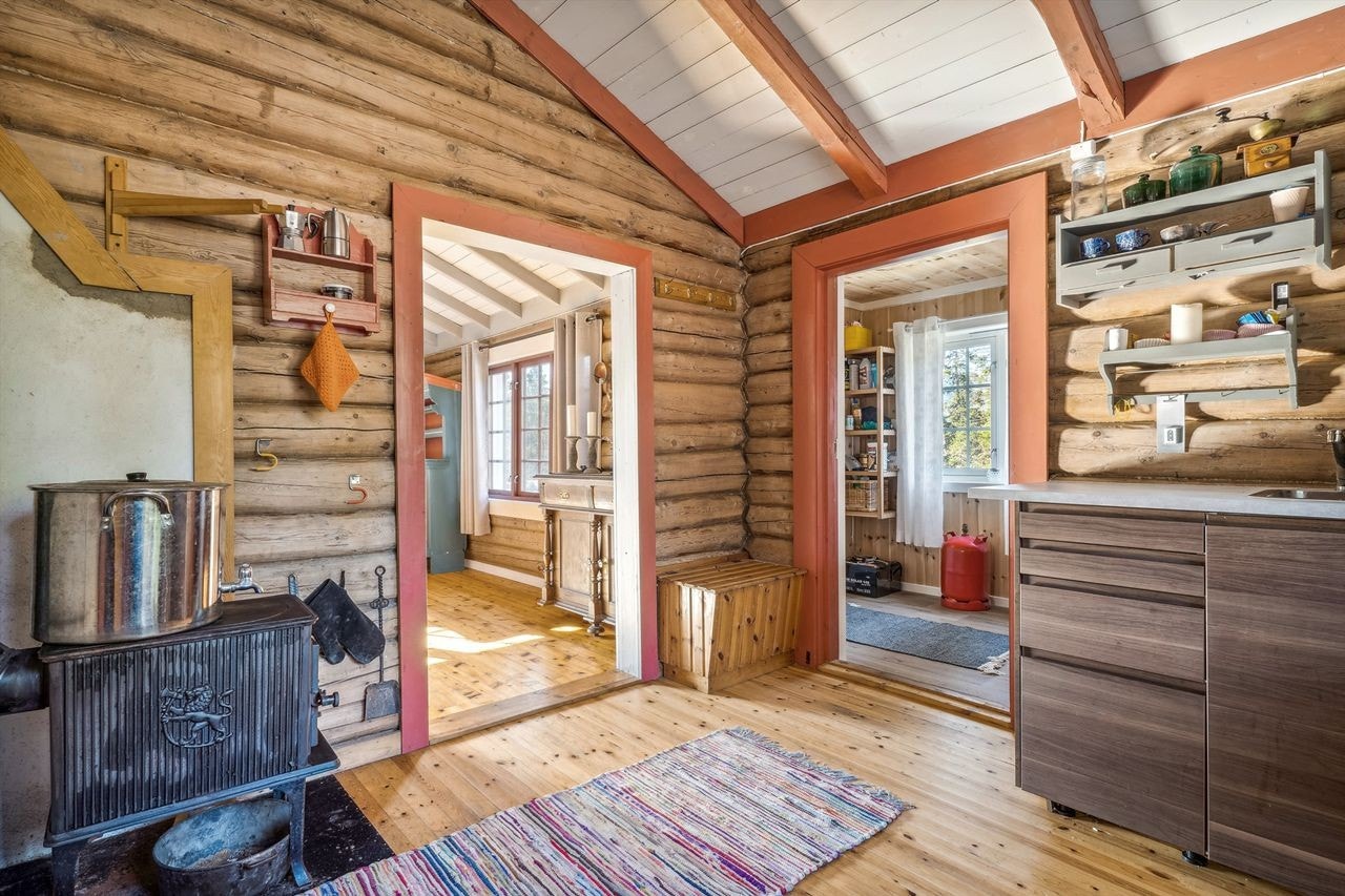 Det er gulvluke på kjøkkenet, og trapp montert på vegg med adkomst opp til hemsen. Vedovn montert på plate i et hjørnet på kjøkkenet, denne gir godt med varme rundt om. Galleribilde