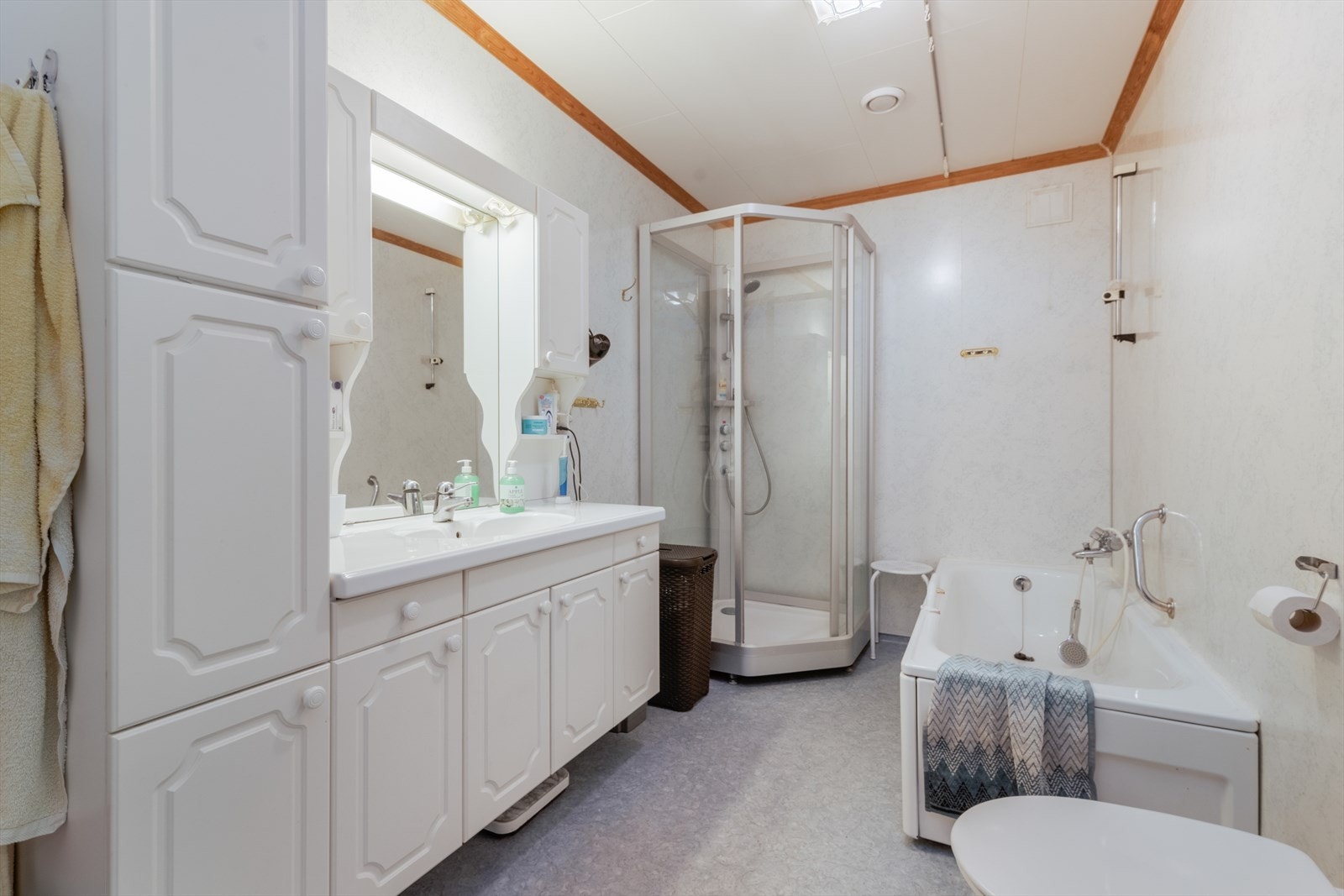 Baderommet er innredet med veggmontert toalett, dusjkabinett, badekar og servantinnredning med underskap, sideskap, speil og lys. Panelovn som varmekilde. Galleribilde