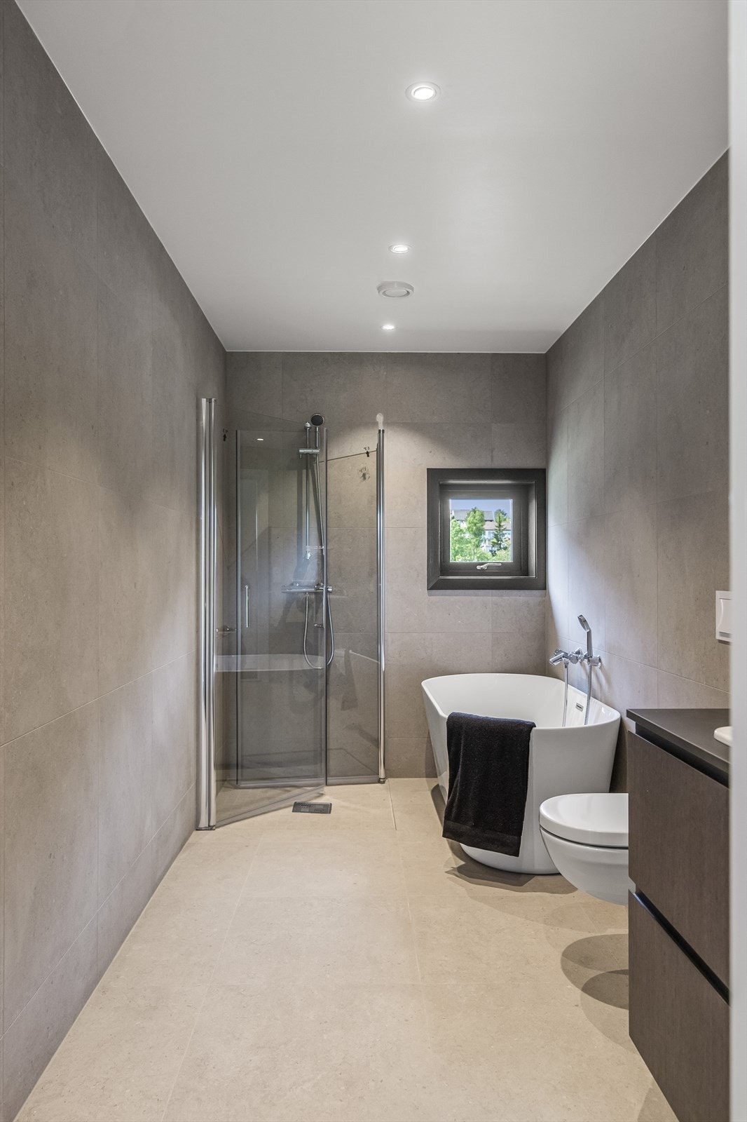 Badet har gulvvarme, badekar, dusjhjørne med glassdører, vegghengt toalett og spottbelysning. Et meget flott og delikat bad en blir glad i! Galleribilde