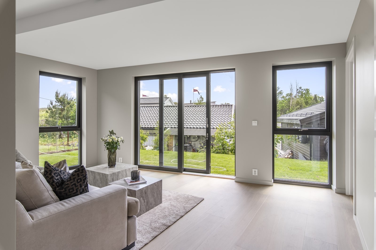 Stuen har store vindusflater og skyvedør i helglass som gir rikelig med naturlig lys i rommet. Galleribilde