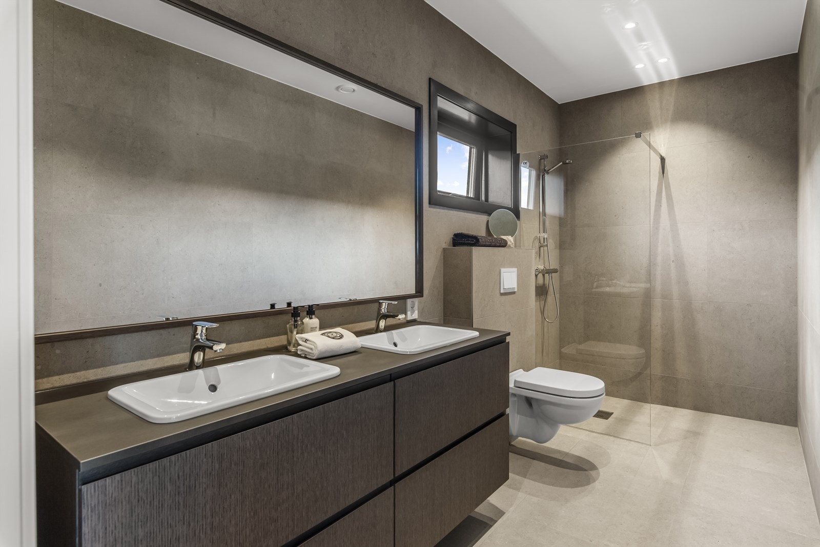 Det er også matchende speil, veggehengt toalett og dusjhjørne med glassvegg. Galleribilde