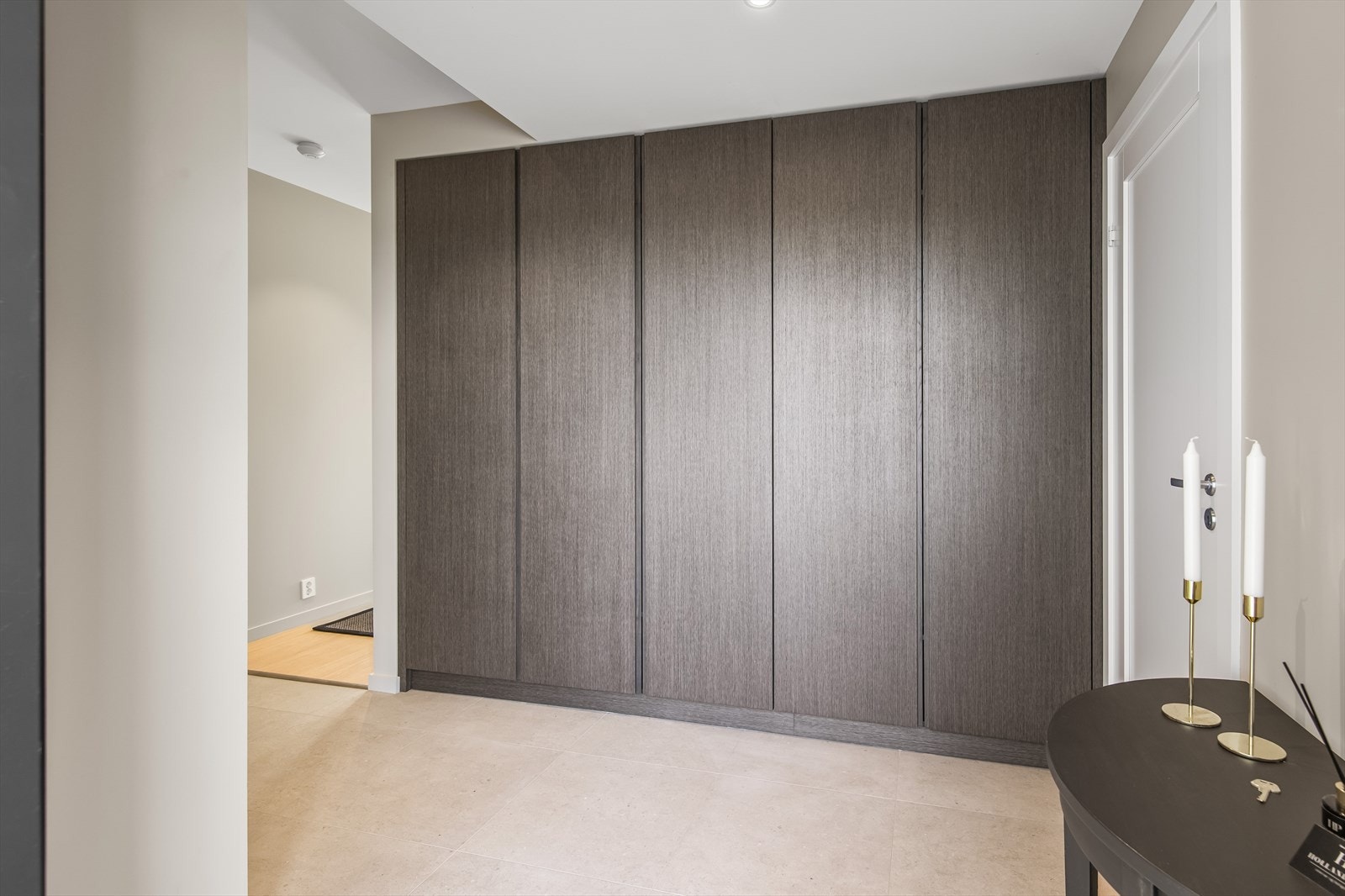 Det innbydende flislagte gulvet videreføres og plassbyge skap som går igjen som er rød trå i boligens innredning. Galleribilde