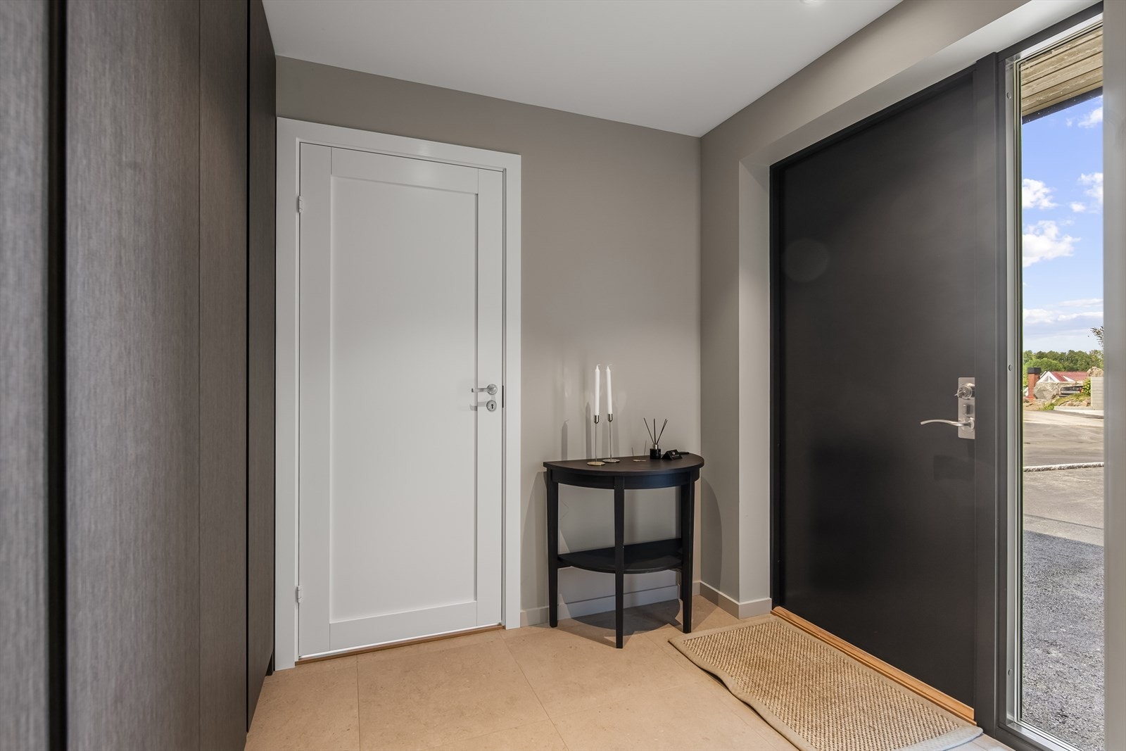 Hovedinngangen har en moderne inngangsdør med stående vindu som gir godt med lys inn. Galleribilde