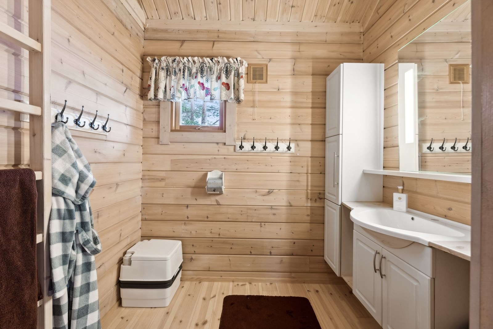 Baderommet innehar servantinnredning med underskap, 2 stk. høyskap, hylle, speil med integrert belysning og portapotti toalett. Galleribilde