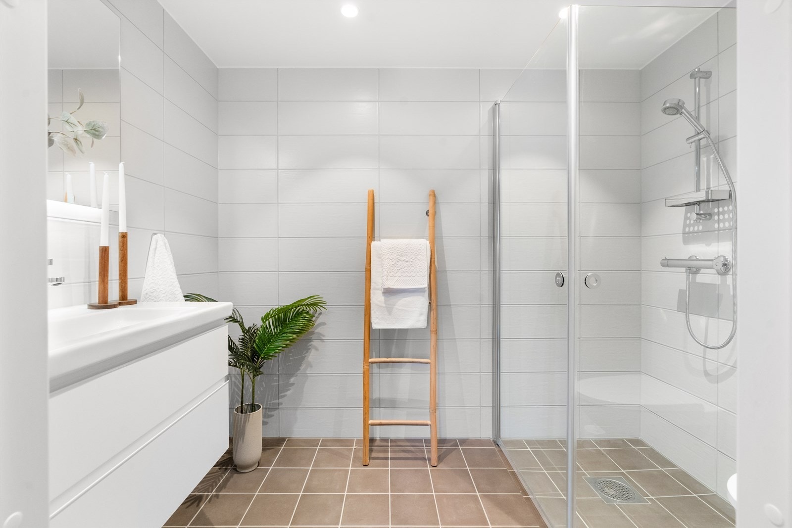 Lyst og romslig baderom med gulvvarme. Badet er bygget opp med dusjhjørne med innfellbare glassdører, vegghengt innredning med servant og vegghengt toalett. Galleribilde