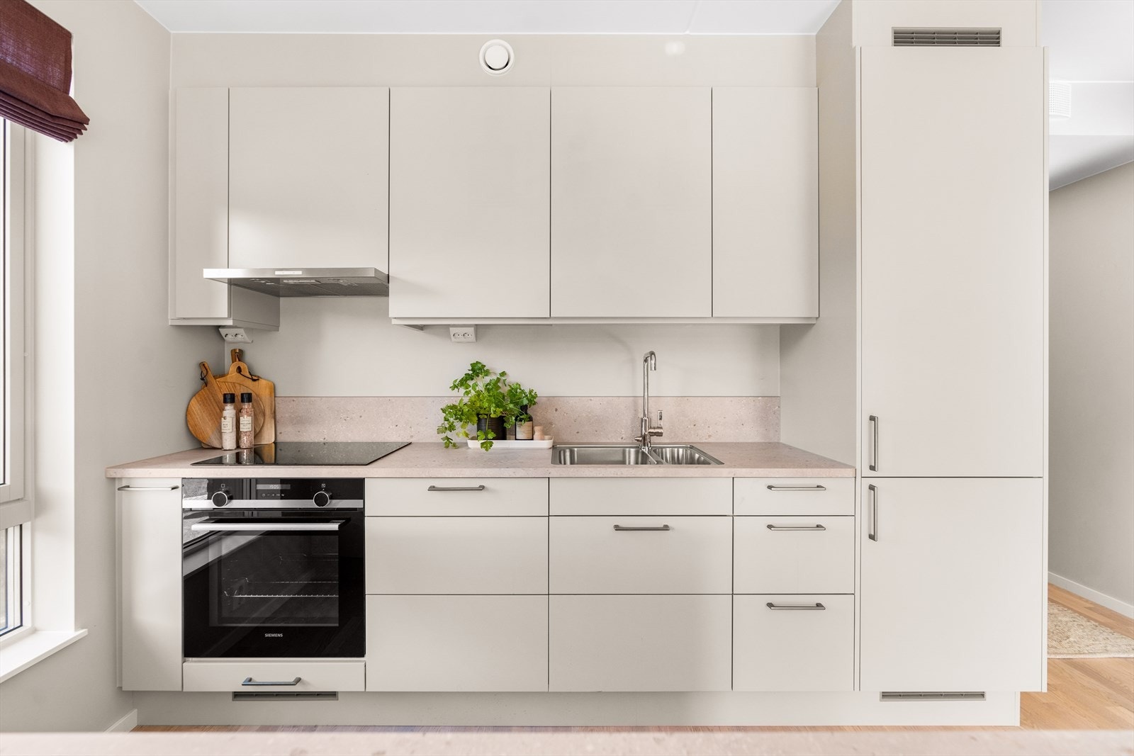 Svært stilrent og moderne kjøkken i samme fargetone som veggene. Galleribilde