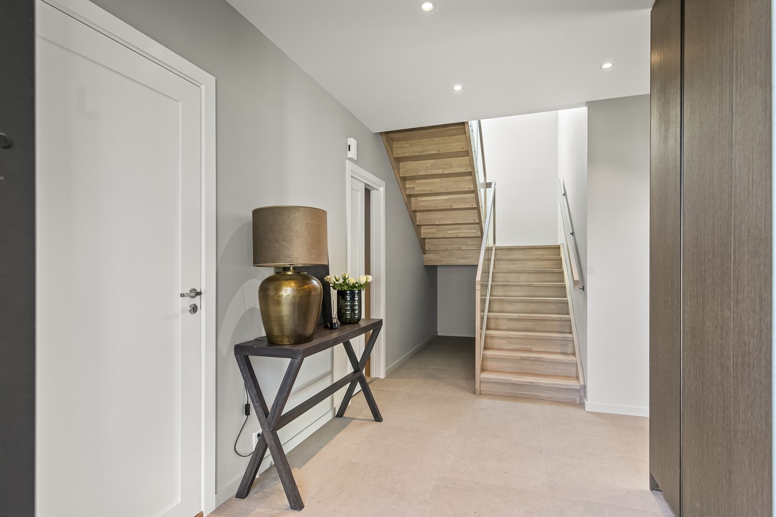 Gangen går over i en hall med et møbel av en trapp kombinert med glassrekkverk. Galleribilde