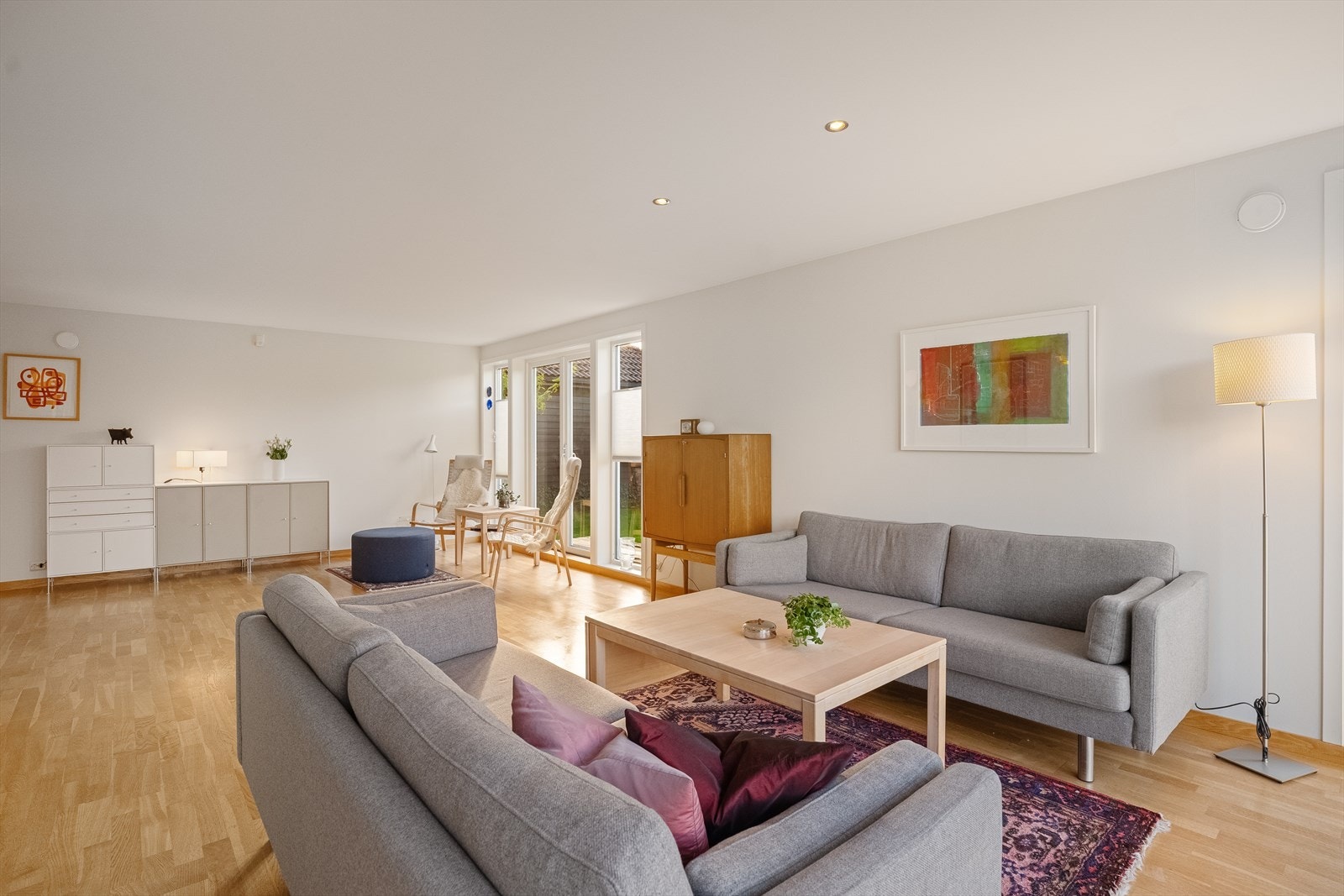 Romslig stue med store vinduer ut mot hagen Galleribilde