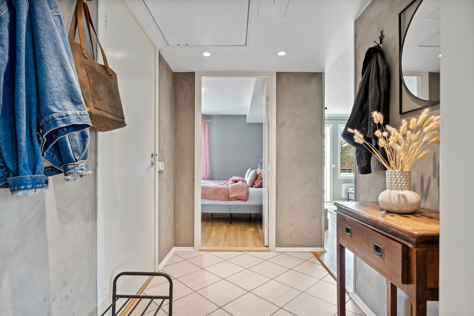 Lettstelt entré med slette overflater, flislagt gulv og downlights i himlingen. Galleribilde