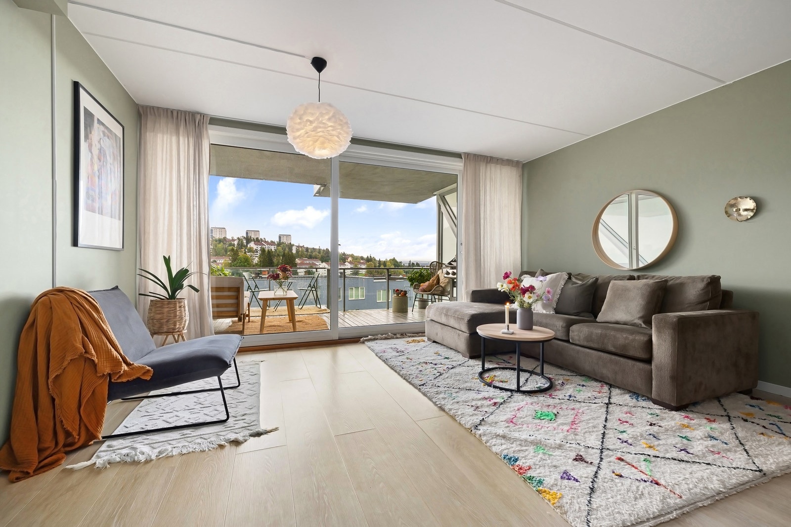 Boligen har en lys stue med store vindusflater som strekker seg fra gulv til tak. Galleribilde