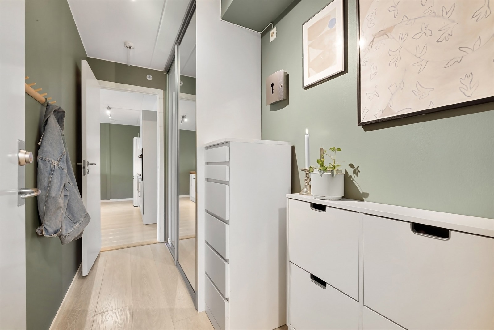 Praktisk og romslig entré med skyvedørsgarderobe og plass til skoskap, kommode eller lignende. Galleribilde