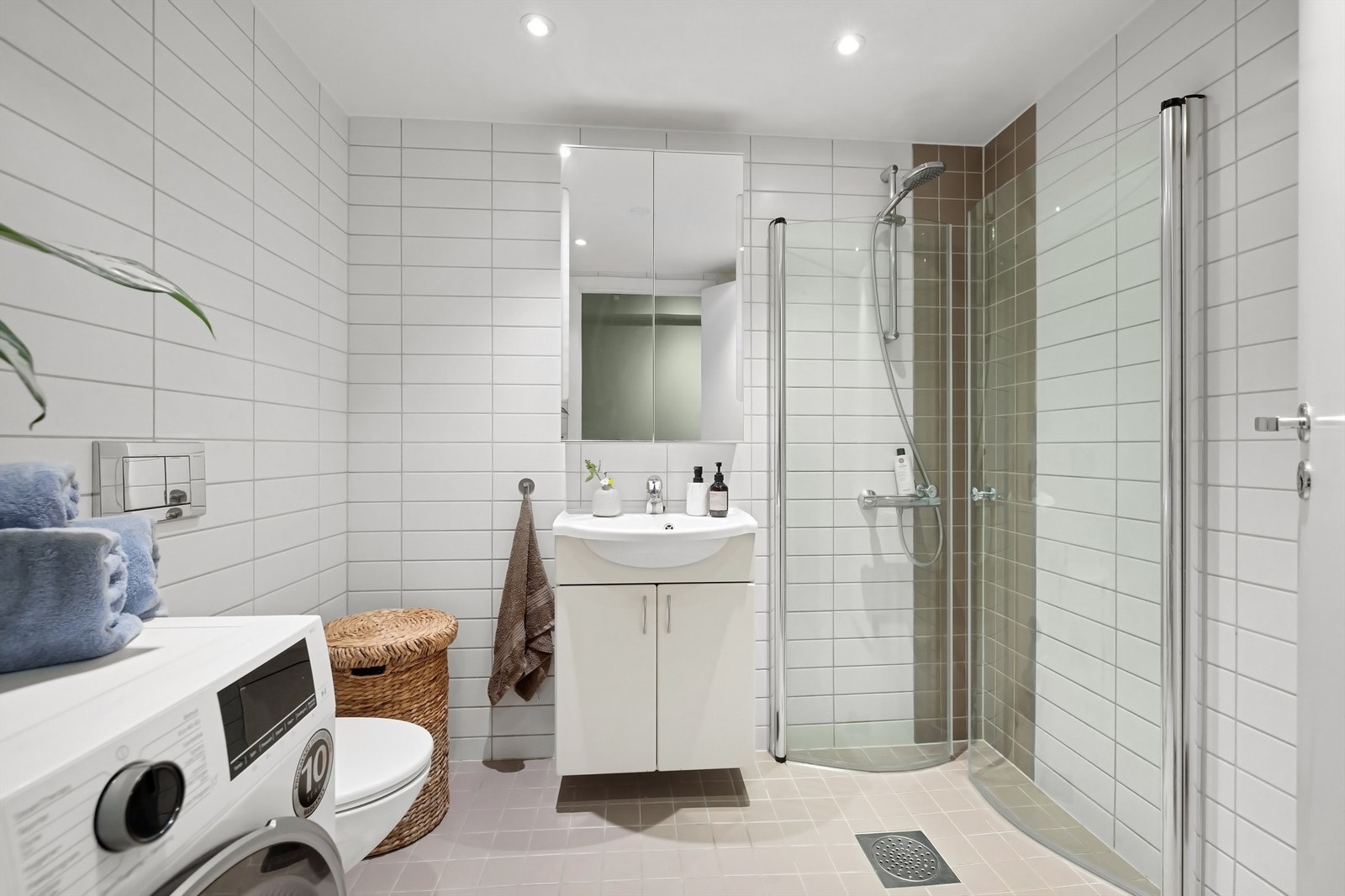 Delikat flislagt bad med varme i gulv og downlights i himling. Galleribilde