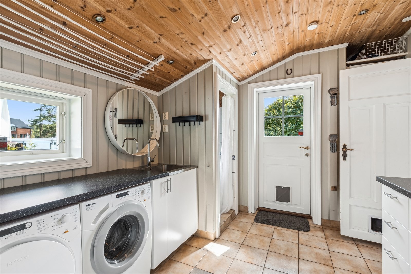 Boligen har et separert og praktisk vaskerom med dusj. Vaskerommet er innredet med: Flere over og underskap, laminerte benkeplater med nedfelt skyllekum, opplegg for vaskemaskin. og plass for tørketrommel under benkeplate. Galleribilde