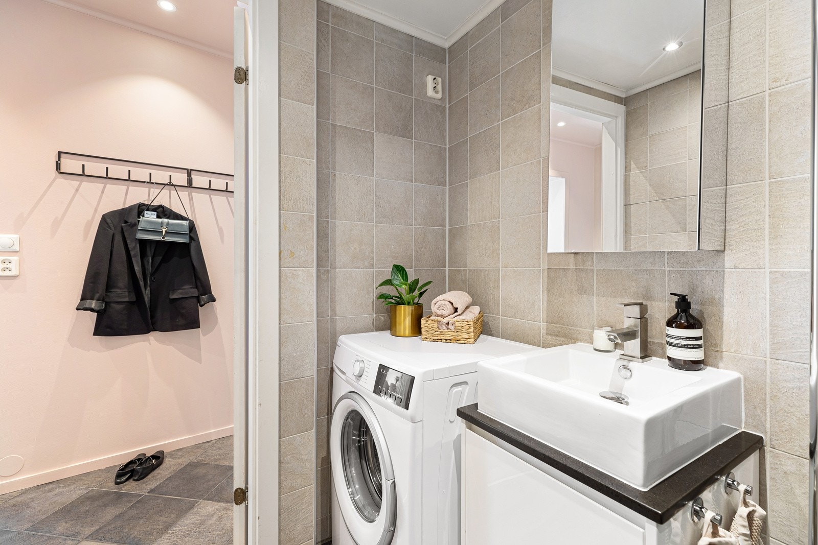 Arealeffektivt baderom med dusjnisje, veggmontert servantskap, toalett og opplegg for vakemaskin Galleribilde