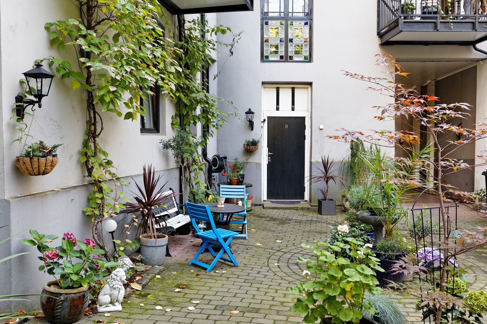 Hyggelig bakgård med flere sittesoner og beplantning Galleribilde