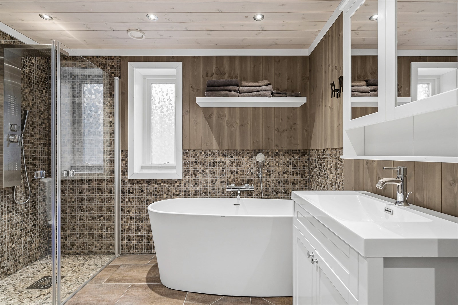 Innbydende bad tilknyttet hovedsoverommet med både dusj, badekar og vaskeromsløsning Galleribilde