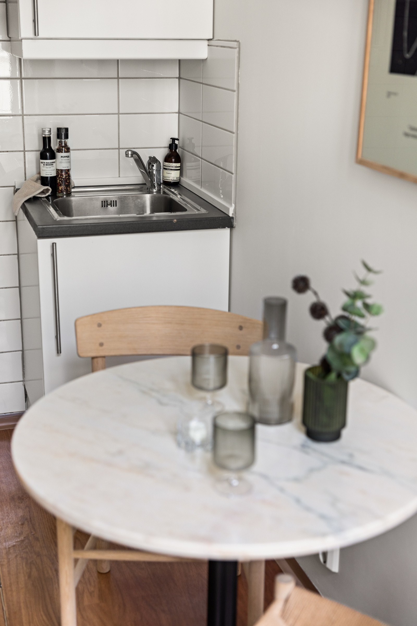 Lys og tidløs kjøkkeninnredning med hvite glatte fronter og laminert benkeplate med nedfelt oppvaskkum. Galleribilde