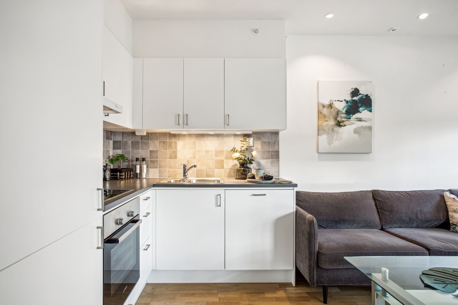 Boligen har et pent, lyst og tidløst kjøkken. Innredningen har benke- og overskap med slette fronter og benkeplate av laminat. Galleribilde